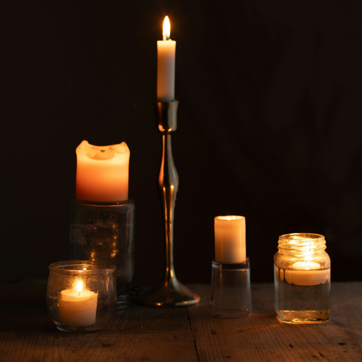 a group of lit candles sitting on top of a wooden table